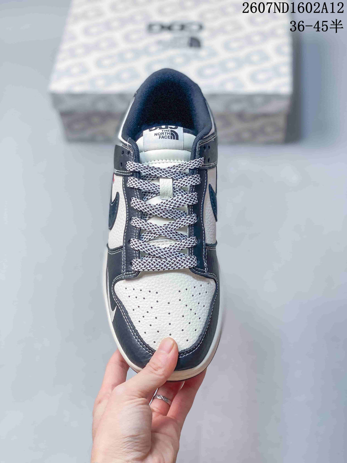 Top-down view of the sneaker showing the perforated off-white toe box, patterned laces, dark navy overlays and branded tongue label; product code and a 36–45 size range appear above.