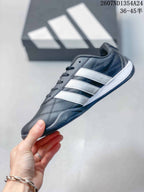 Side profile of the dark trainer with three contrasting white side stripes.