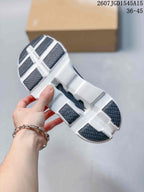 Underside view showing the white outsole, open geometric sections, and dark rubber tread panels.