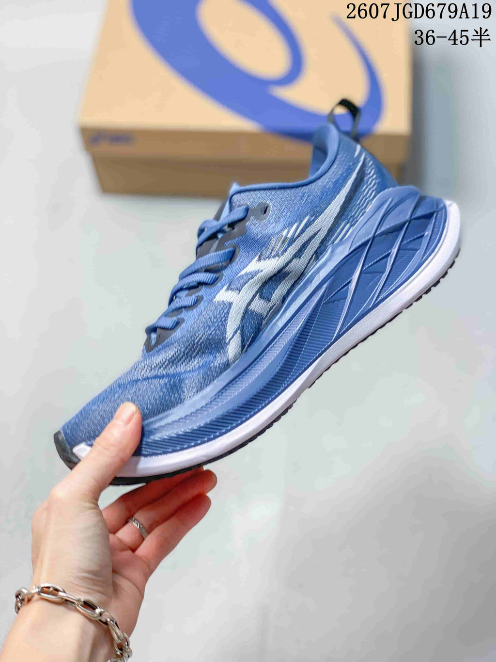 Side profile of the blue ASICS running sneaker showing the lace-up upper, side branding, layered midsole, and black outsole edge.