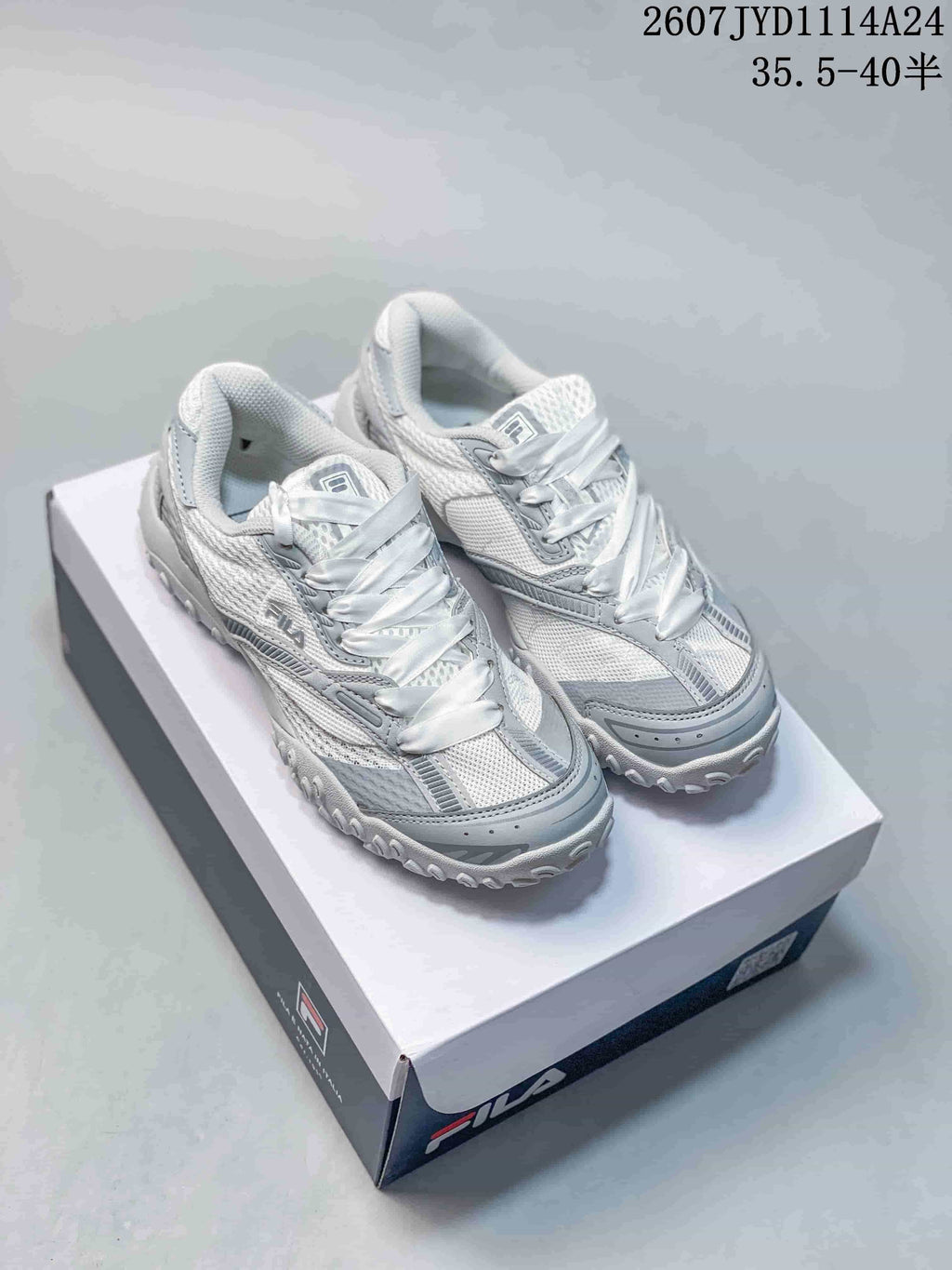 Pair of white and gray FILA Fusion ECHAPPE 2 sneakers displayed on a shoebox.