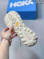 Underside view of the sneaker outsole showing a pronounced lug pattern and a yellow Vibram-marked insert.