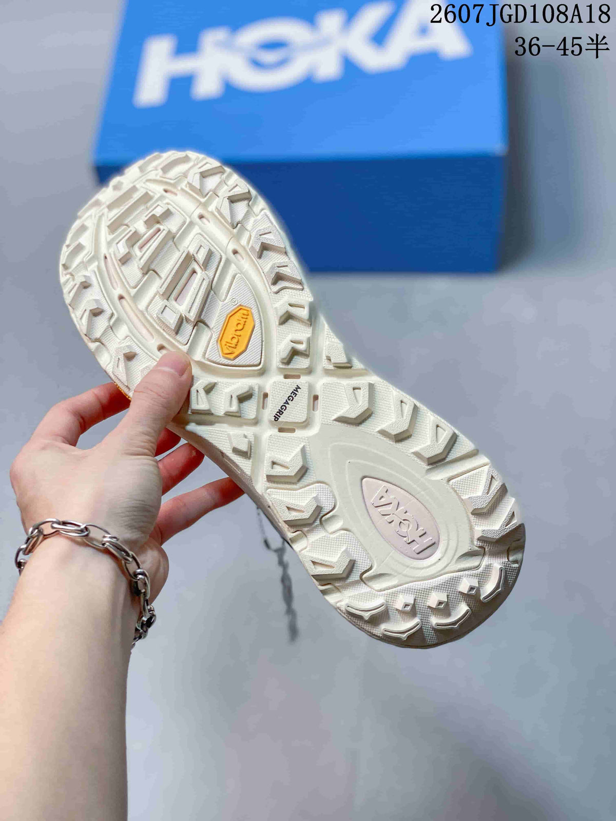 Underside view of the sneaker outsole showing a pronounced lug pattern and a yellow Vibram-marked insert.