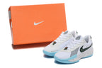 Pair of white and light blue Nike basketball shoes beside an orange Nike-branded box.
