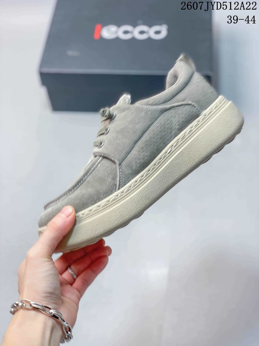 Side view of a gray ECCO lace-up sneaker showing stitched panels, a perforated side section, and a textured outsole.