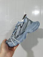 Cyan blue sneaker shown from the opposite side, highlighting the layered upper and segmented outsole.