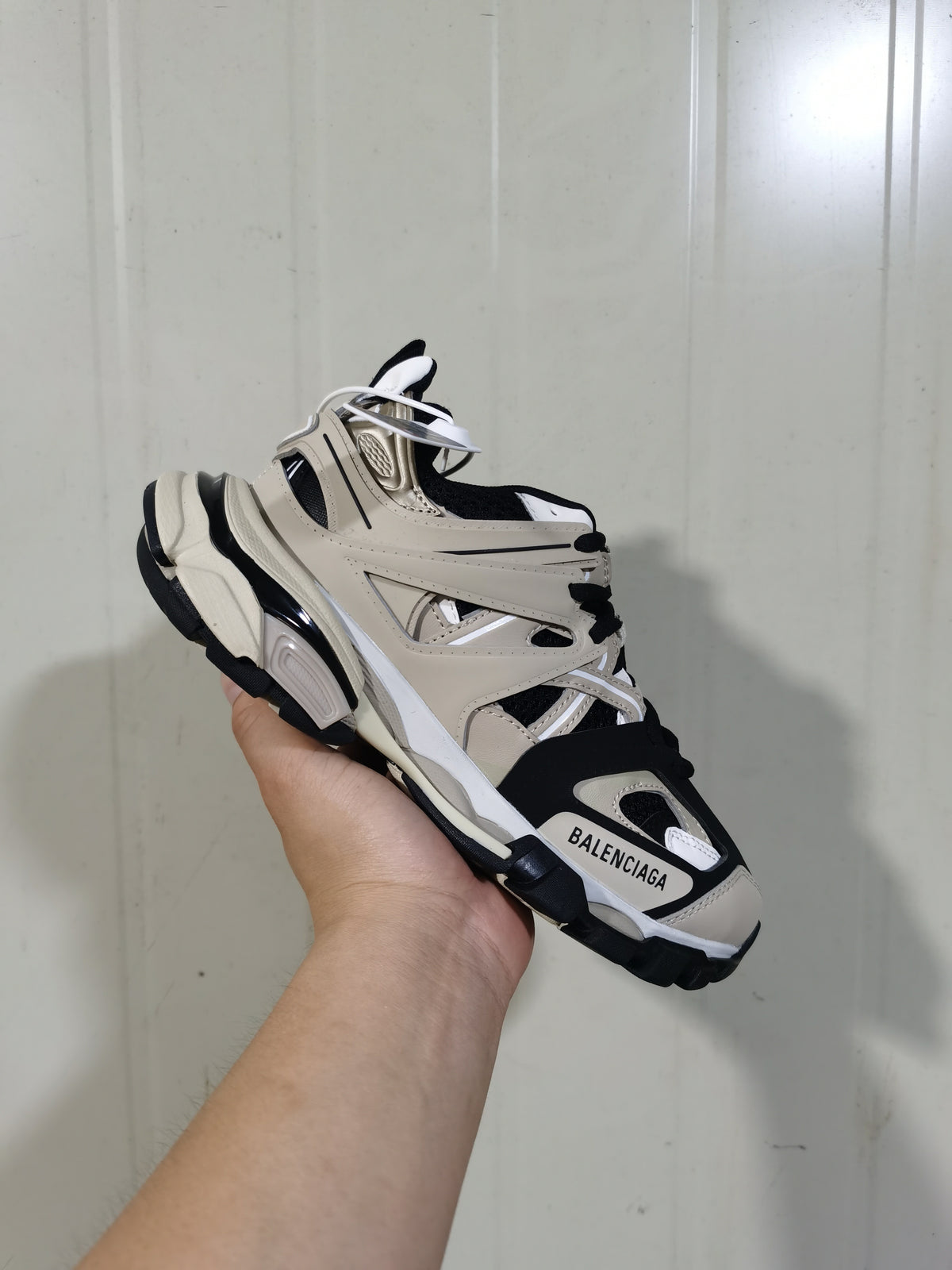 Beige and black Balenciaga Track sneaker shown from a front three-quarter angle.