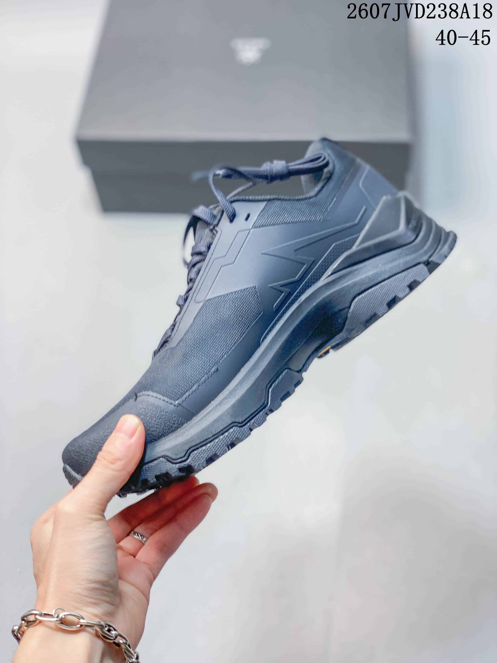 Side view of the dark gray low-top hiking shoe showing structured upper panels, protective overlays, and rugged tread.