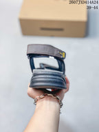Rear view of a brown sandal showing the heel strap, padded rear section, and dark outsole.