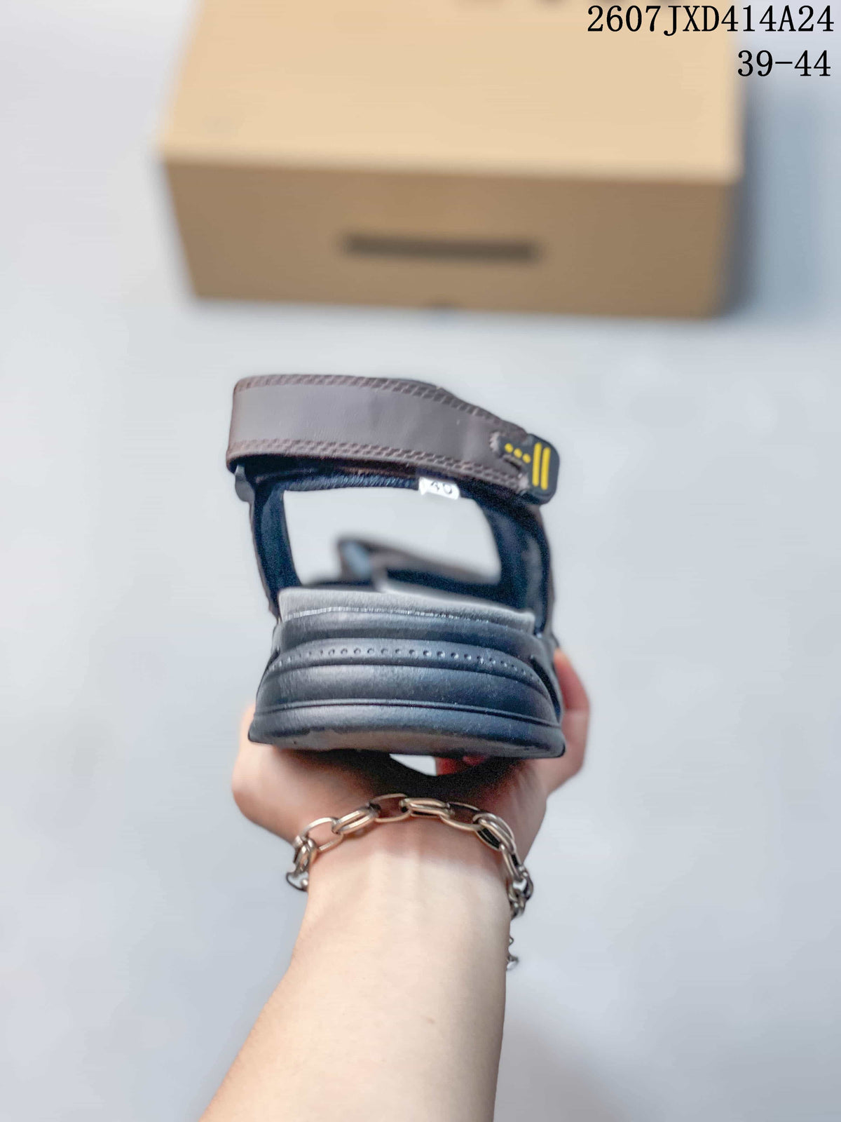 Rear view of a brown sandal showing the heel strap, padded rear section, and dark outsole.