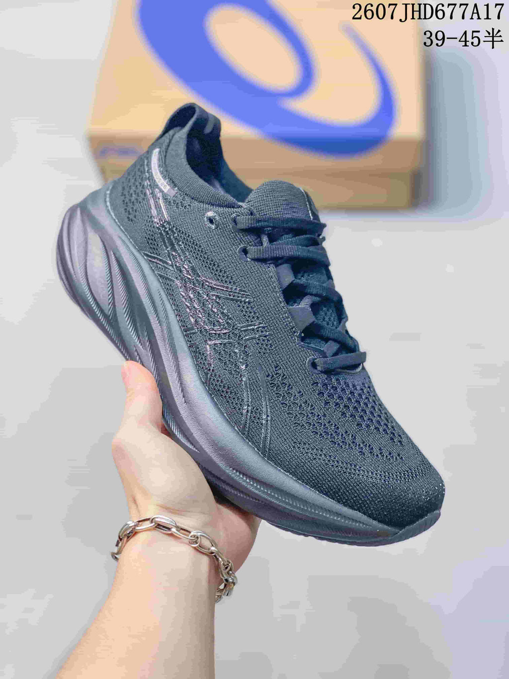 Angled side view of a black ASICS Gel-Nimbus 26 running shoe showing the textile upper, side branding and thick sole.