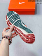 Close view of the patterned outsole on a green and orange Nike running shoe, with an orange Nike box in the background.
