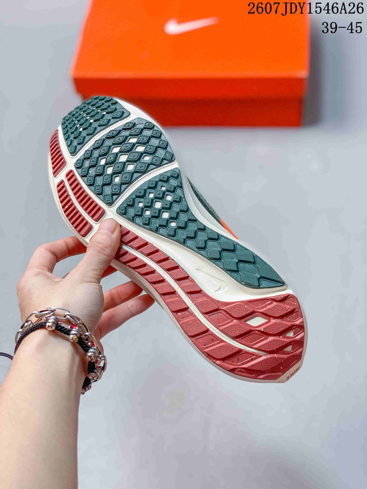 Close view of the patterned outsole on a green and orange Nike running shoe, with an orange Nike box in the background.