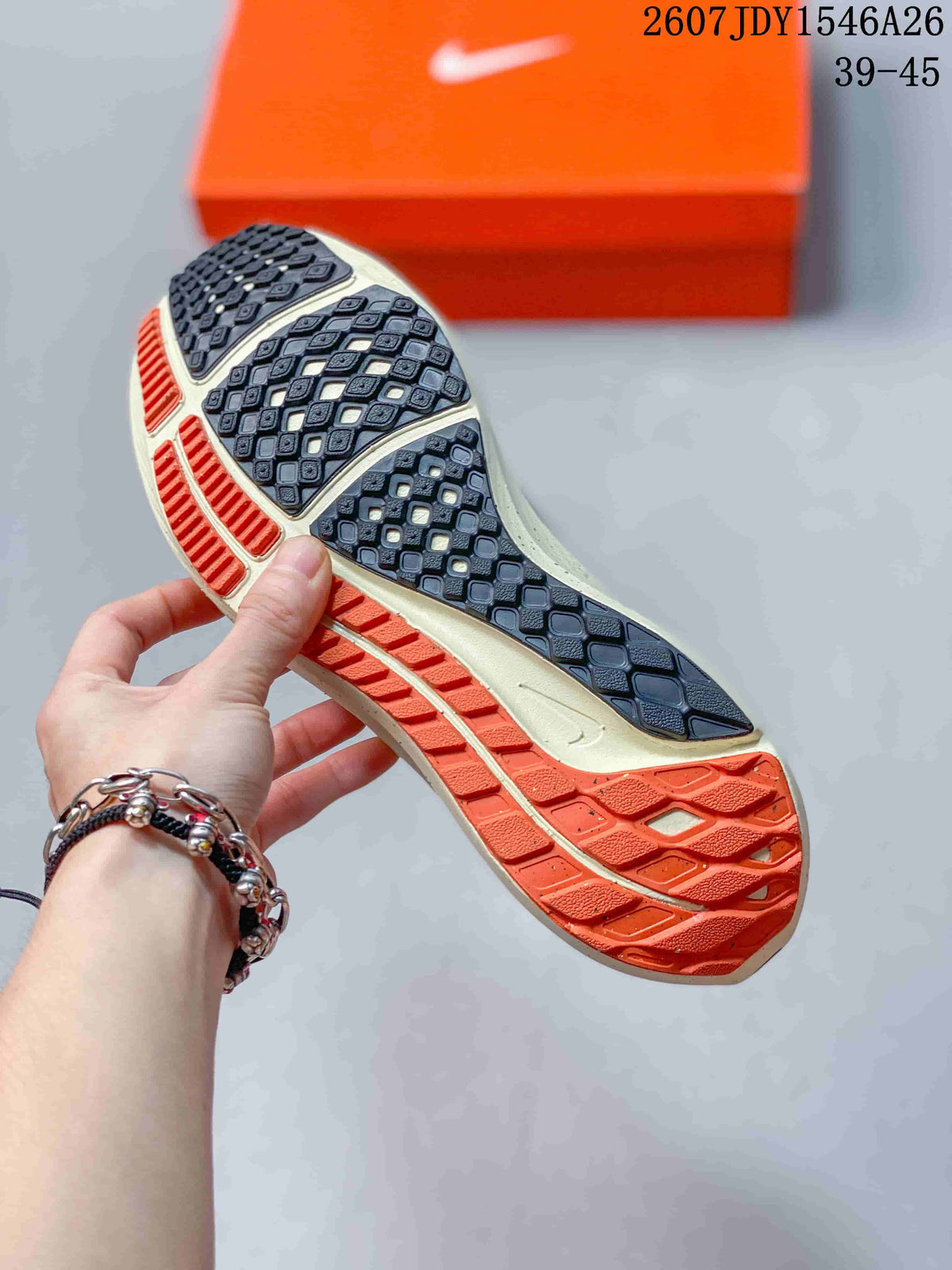 Close view of the patterned outsole showing dark traction sections with orange and cream-colored areas.
