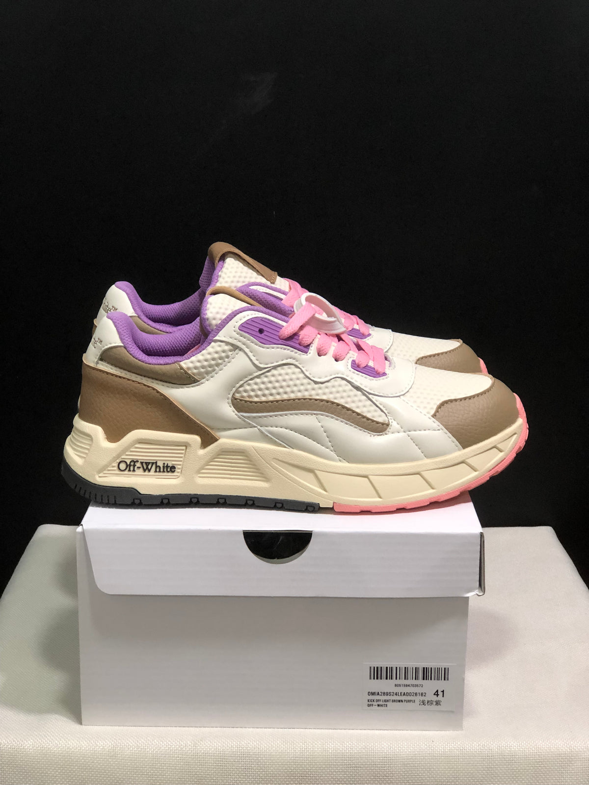 Side view of the Off-White-branded low-top sneakers with pink laces, purple lining, beige panels, and a cream midsole.