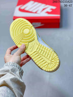 Underside view of a sneaker showing the yellow rubber outsole and circular traction pattern.