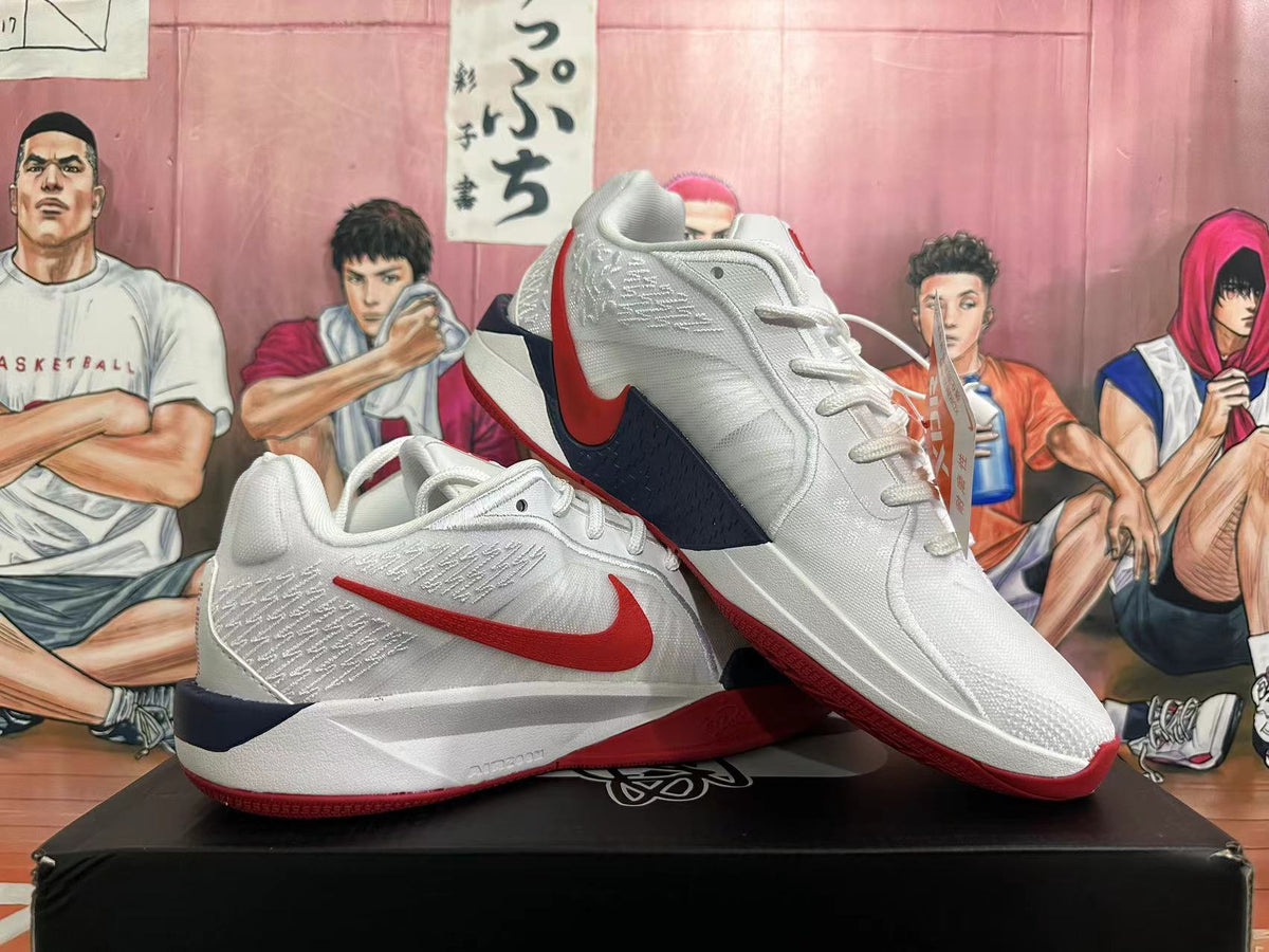 Pair of white Nike basketball shoes with red Swooshes and navy accents, shown from the side.