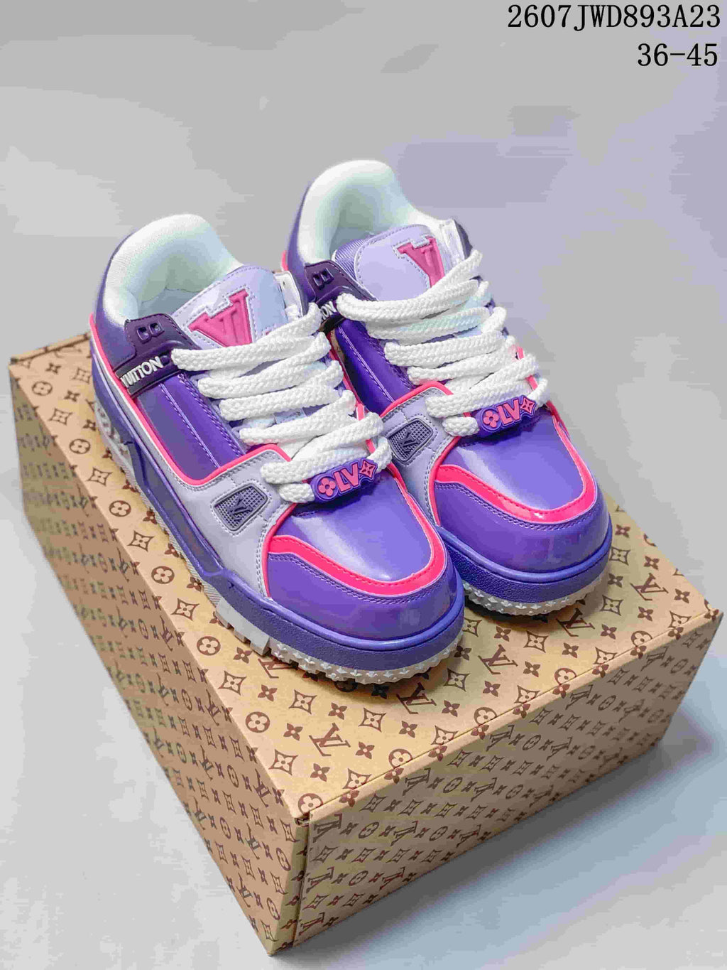 Pair of purple, pink, white, and grey Louis Vuitton Trainer Maxi Low sneakers displayed on a patterned box; image text shows style code 2607JWD893A23 and size range 36-45.