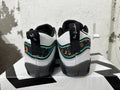 Rear view of black, white, and green Jordan basketball shoes with floral-patterned heel panels.