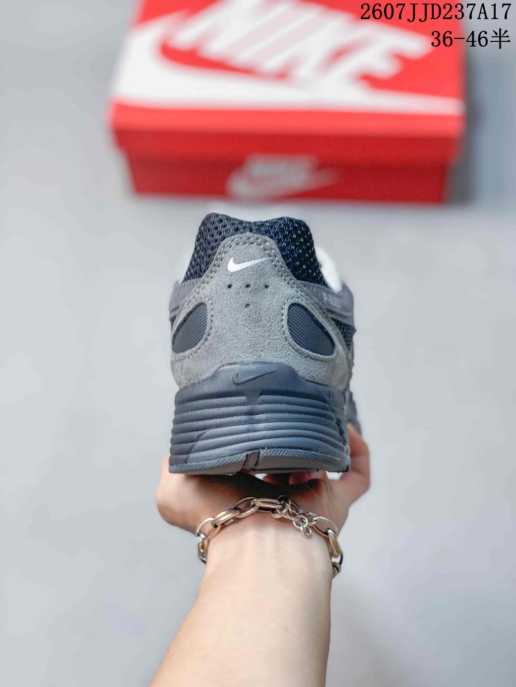 Rear view of a gray and black sneaker showing the padded heel, layered heel panel, and ribbed midsole.