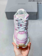 Front view showing the white laces, pink overlays, mesh-style toe panel, and branded tongue.