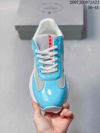 Top view showing the rounded toe, white laces, turquoise panels, and red tongue label.