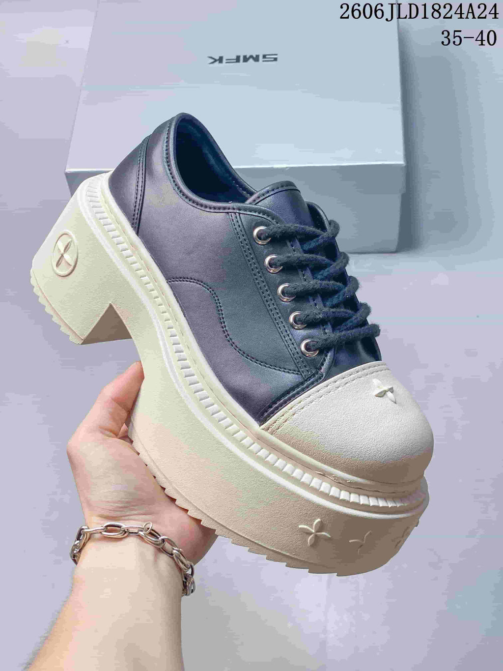 Angled view of a dark and ivory low-top sneaker with a chunky platform sole