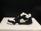Side profile of one sneaker showing the layered black and white upper and white outsole.