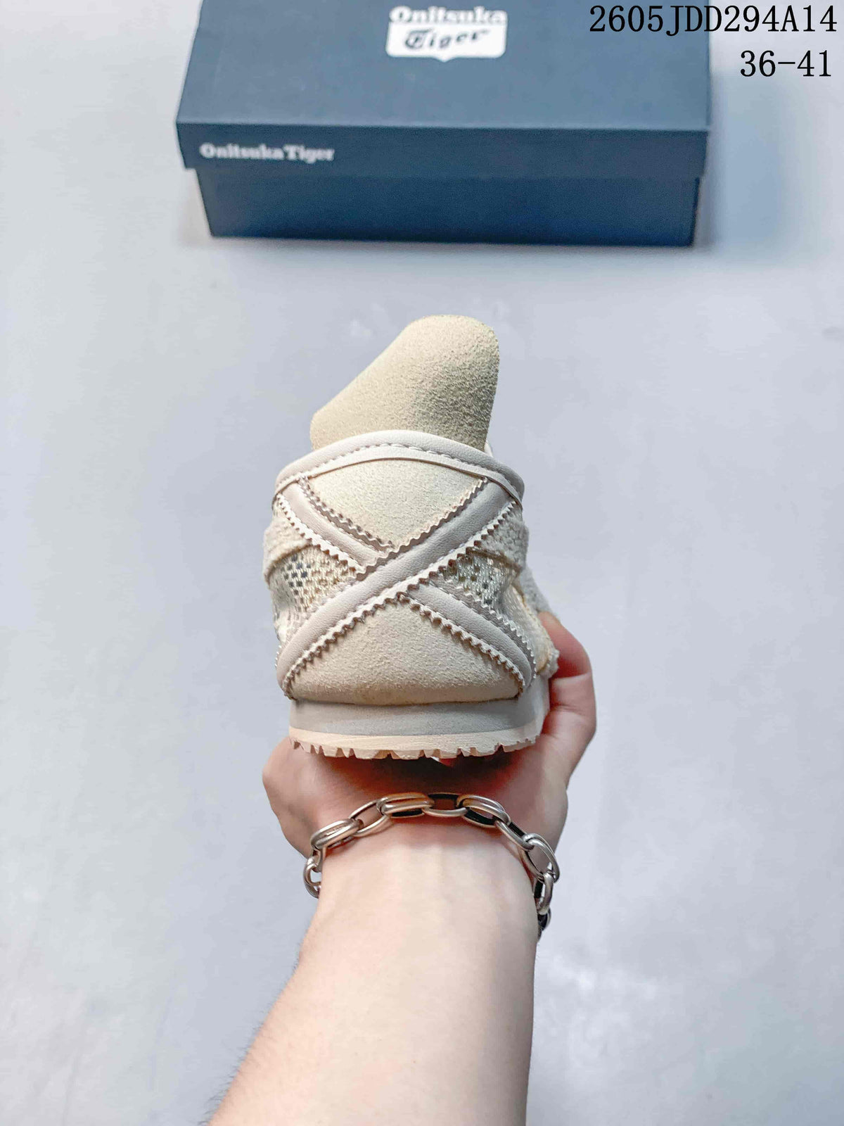 Rear view of the cream-toned sneaker showing the heel construction, layered panels, and outsole edge.
