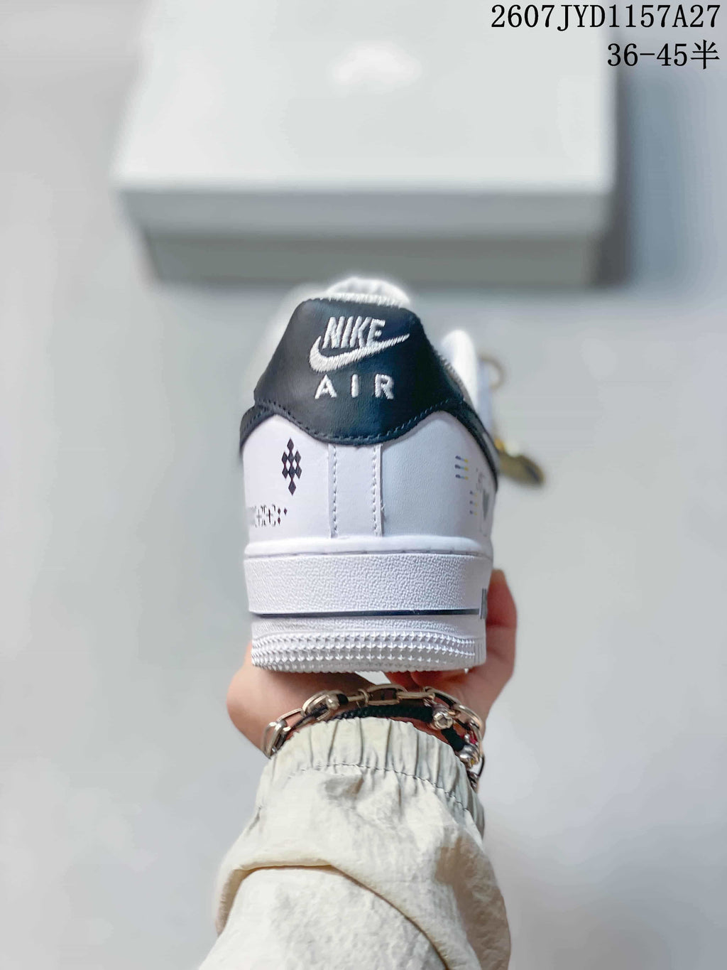 Rear view of a white and black sneaker showing the Nike Air tongue label, heel graphics, and textured white sole.