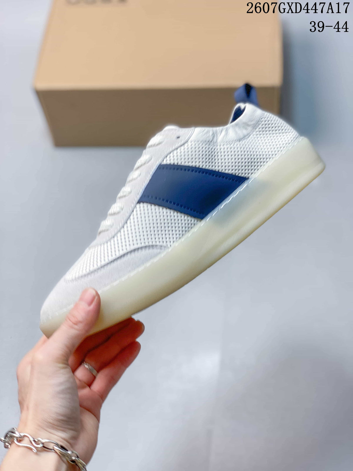Side view showing the perforated white upper, blue side panel, laces, and light-colored outsole.