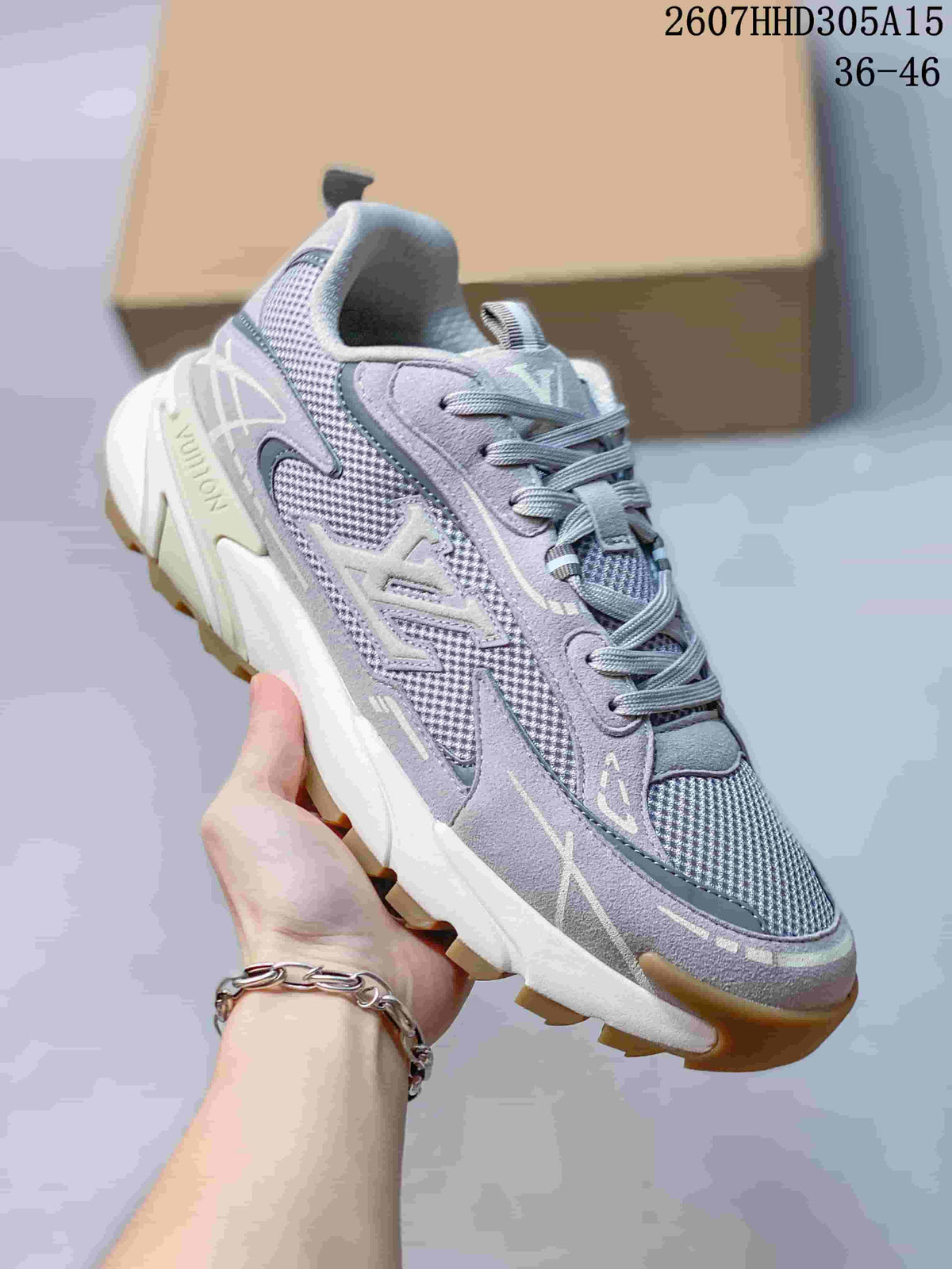 Angled side view of the gray sneaker showing the layered upper, mesh inserts, lace system, white midsole, and tan outsole.
