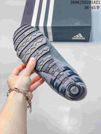 Bottom view of a gray sneaker showing the patterned rubber outsole and circular heel detail.
