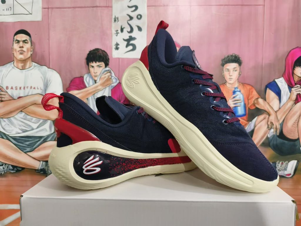 Angled view of navy basketball shoes with red details and pale cream-colored soles