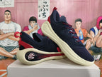 Angled view of navy basketball shoes with red details and pale cream-colored soles