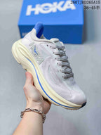 Angled side view of a light-colored HOKA Clifton 10 sneaker showing the logo, blue accent stripe, and cushioned sole.