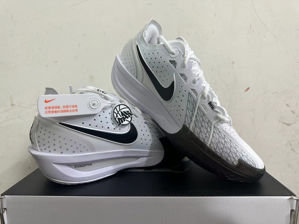 White Nike basketball shoes shown from the side, highlighting perforated panels and black accents.