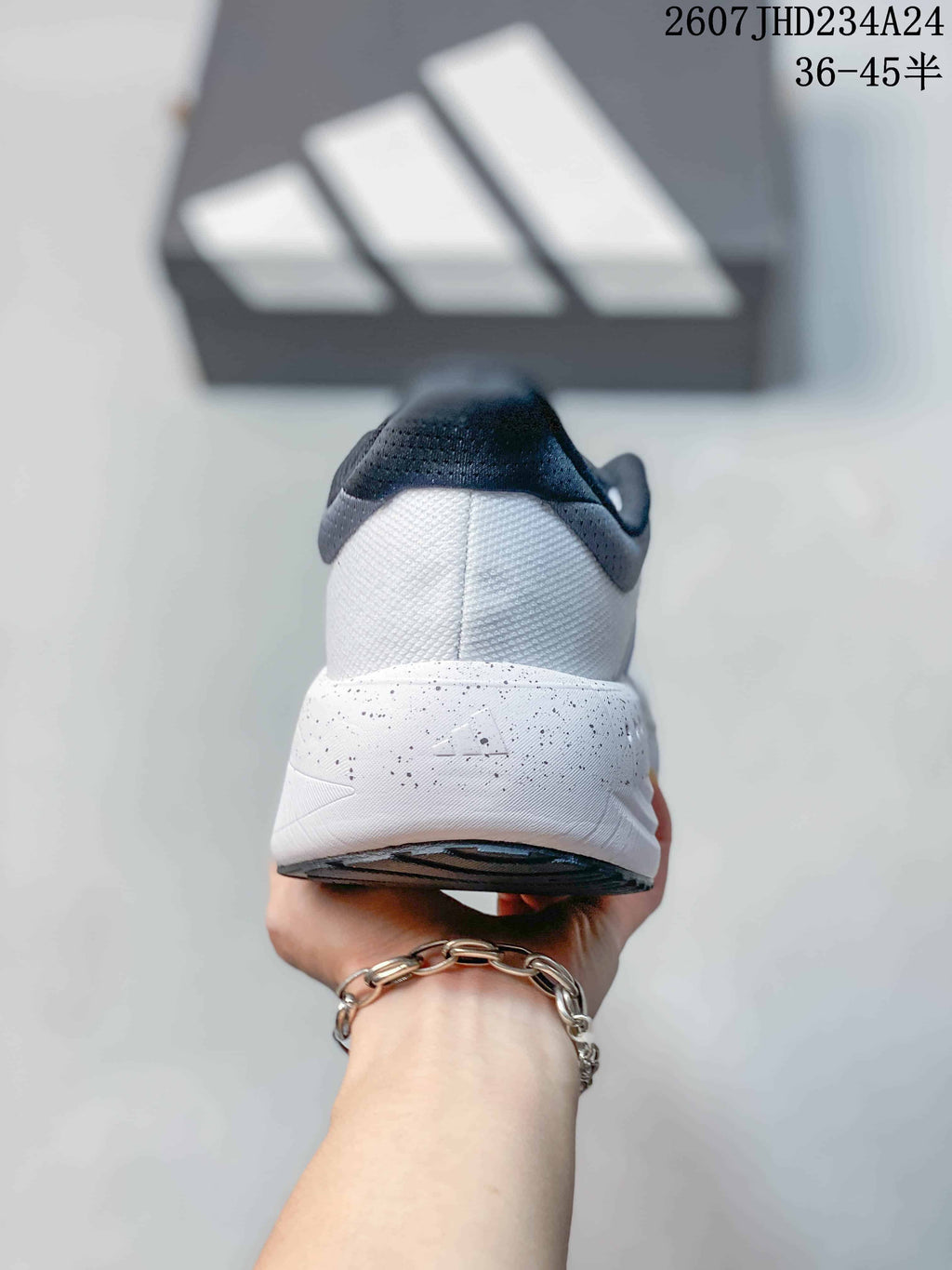 Rear view showing the white heel, dark padded collar and speckled midsole.