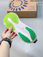 Underside of the shoe showing white and green outsole sections
