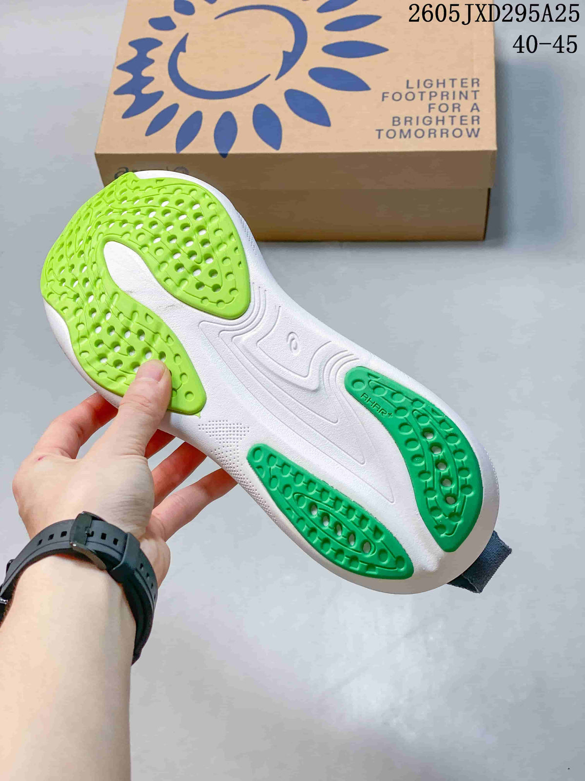 Underside of the shoe showing white and green outsole sections