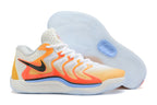 White and orange Nike KD 17 basketball shoes with yellow and pale blue accents.