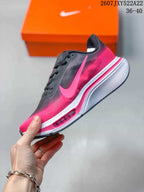 Side profile showing the pink Nike Swoosh, black upper panels, layered midsole, and visible Air Zoom marking.