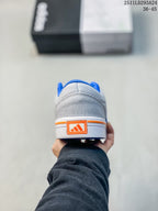 Rear view of the grey sneaker showing the orange heel branding and blue collar lining.