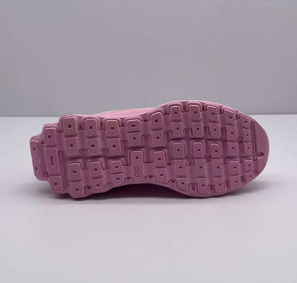 Underside view of the pink sneaker showing the patterned rubber outsole.