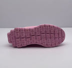 Underside view of the pink sneaker showing the patterned rubber outsole.