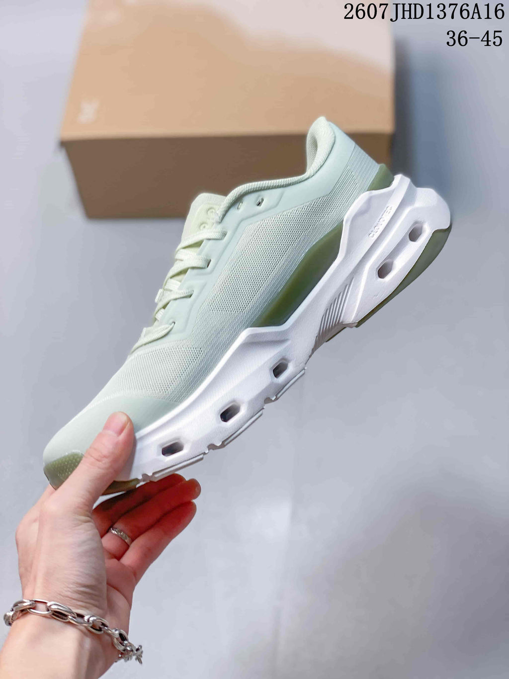 Side view of a pale mint green and white On Cloudpulse 2 sneaker showing the mesh-style upper, layered panels, and sculpted midsole.