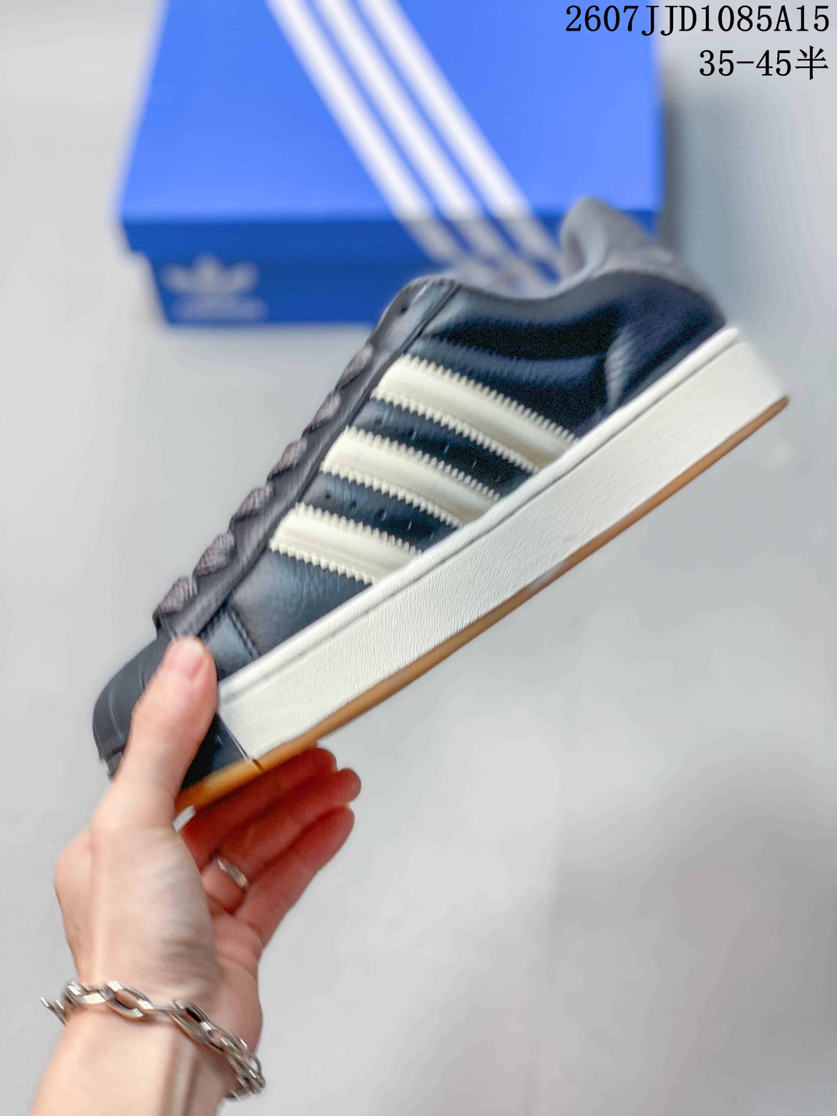Side view of the black low-top sneaker showing light three-stripe details, a raised white midsole, and gum outsole.