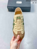 Top view of the beige slip-on sneaker showing the tongue panel, eyelet details, green branding, and brown toe overlays.