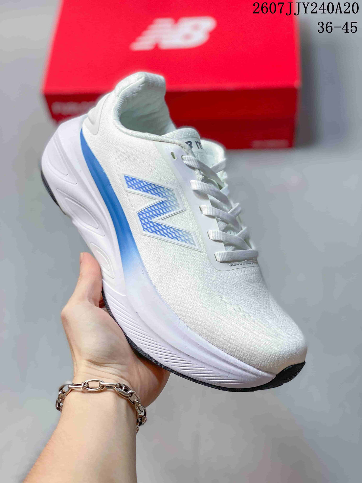 Angled side view of the white and blue New Balance sneaker with a raised midsole.
