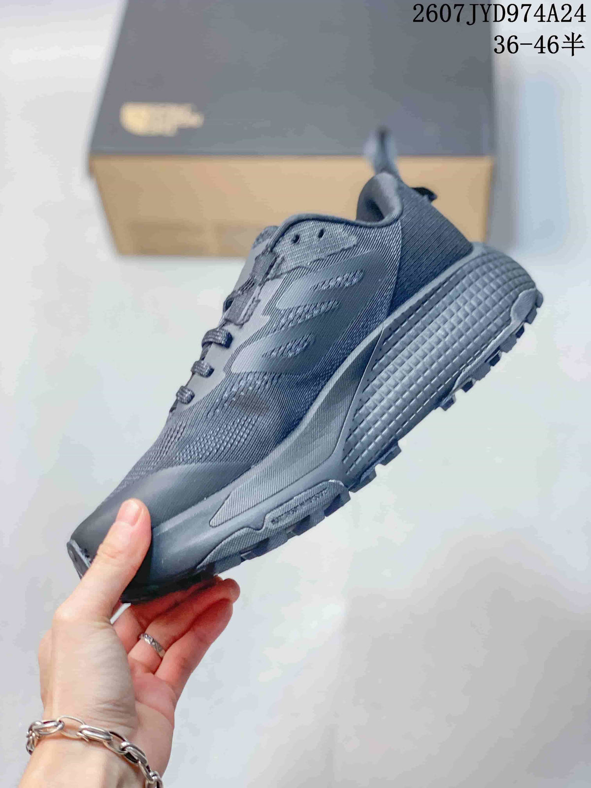 Side view of the dark gray sneaker showing the mesh-like upper, layered side panels, textured midsole, and lugged outsole.